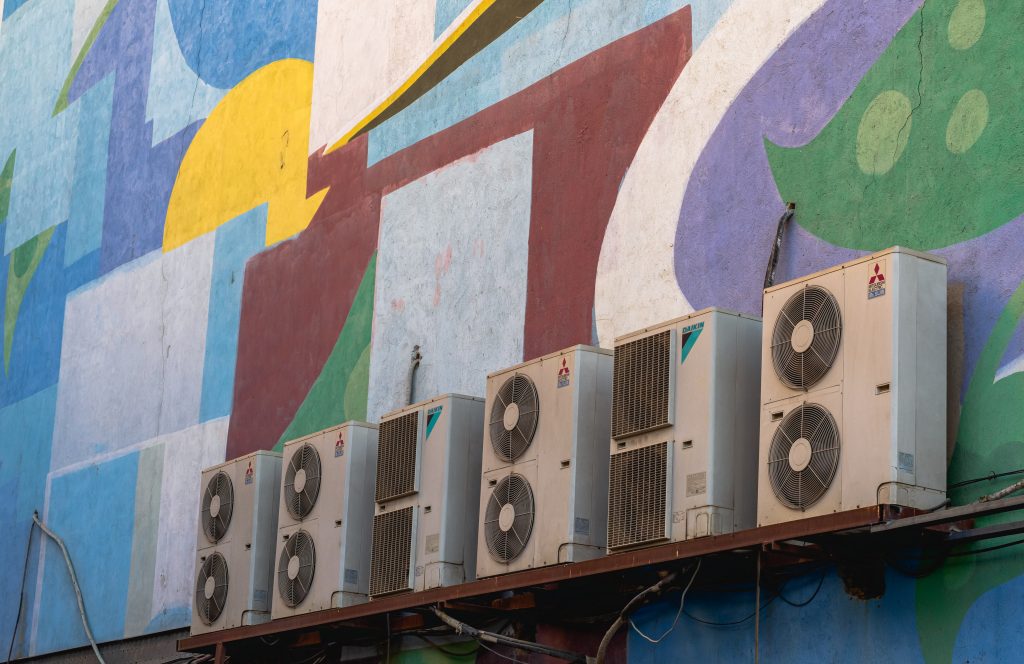 A row of air conditioners used to represent the concept "how long does an air conditioner last?"