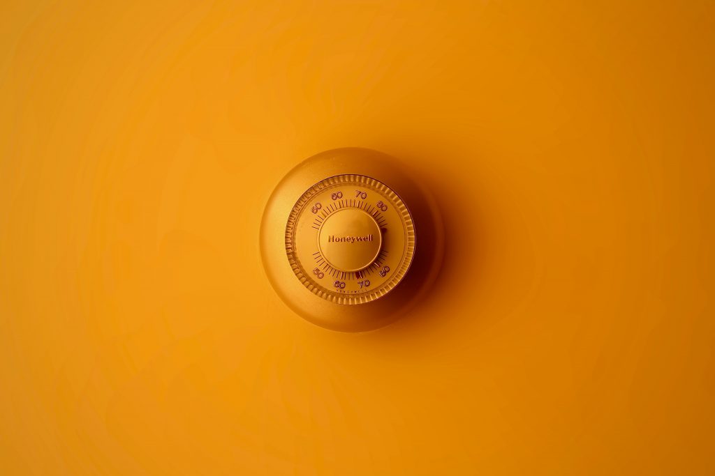 A Honeywell thermostat used to represent the concept of "how many degrees can an air conditioner cool?"