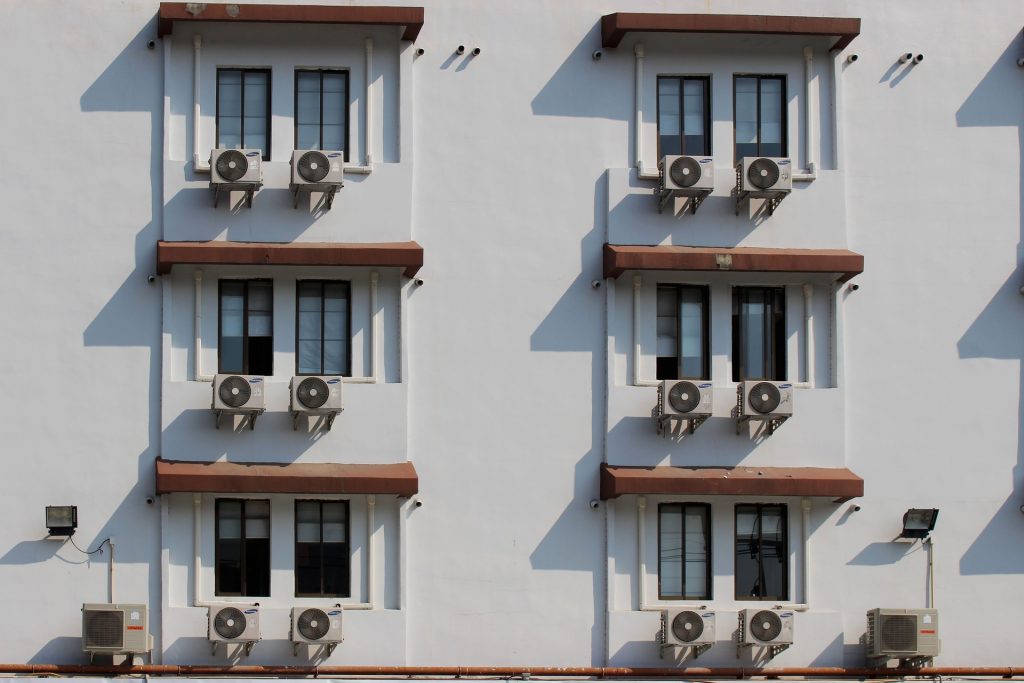 A row of air conditioners used to represent the concept of central air vs. mini split.