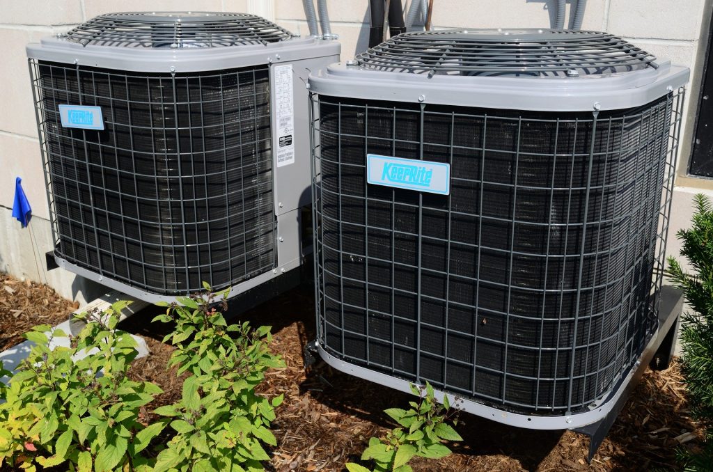 Two central types of air conditioners sitting side by side.