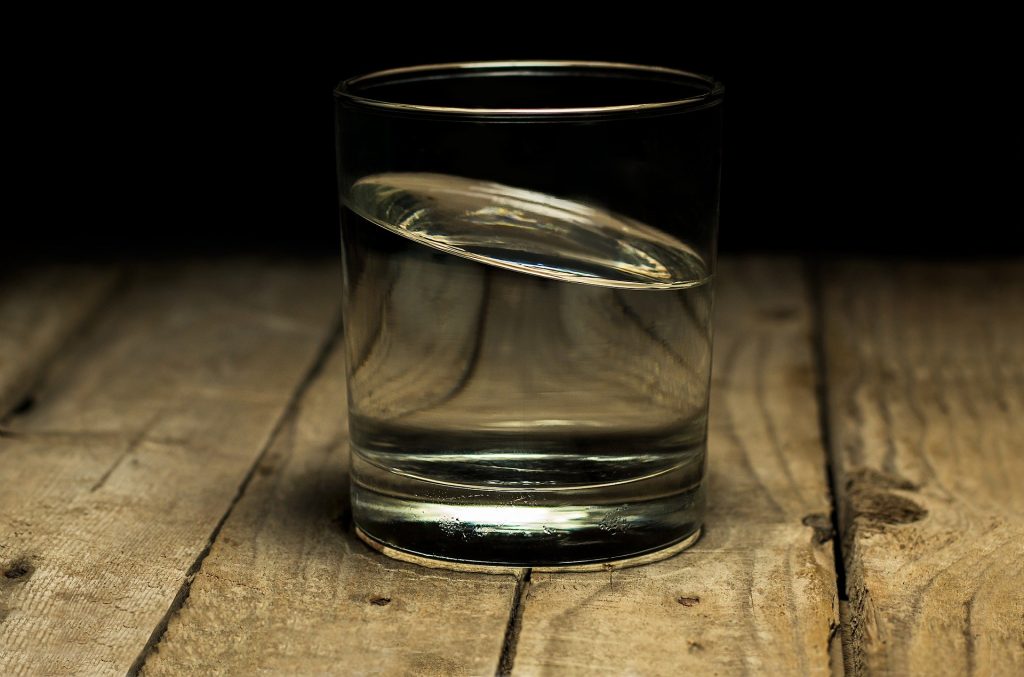 A glass of water used to represent the concept of changing a reverse osmosis filter.