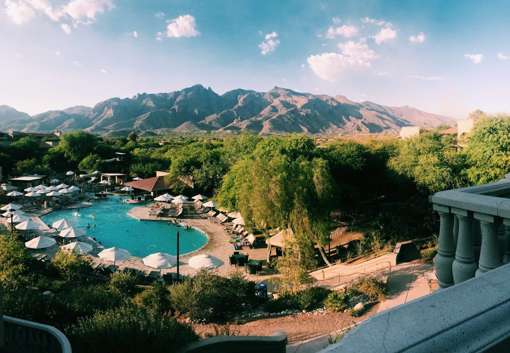 A poolside view of an Arizona resort, with desert hills in the background.