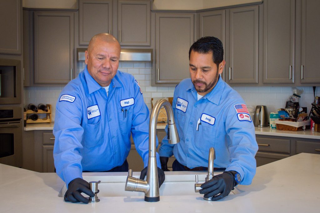 plumbing specialists inspecting kitchen sink
